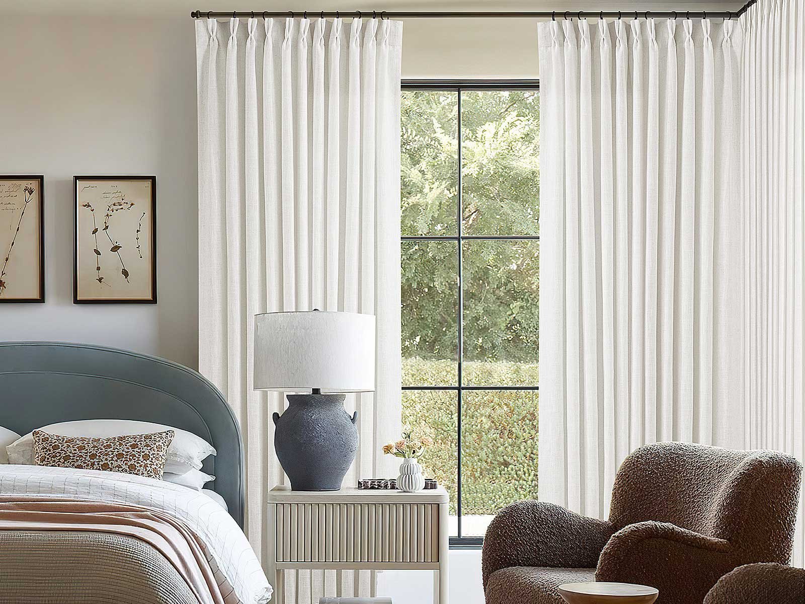 Blackout pinch pleat curtains in a bedroom providing privacy and light control